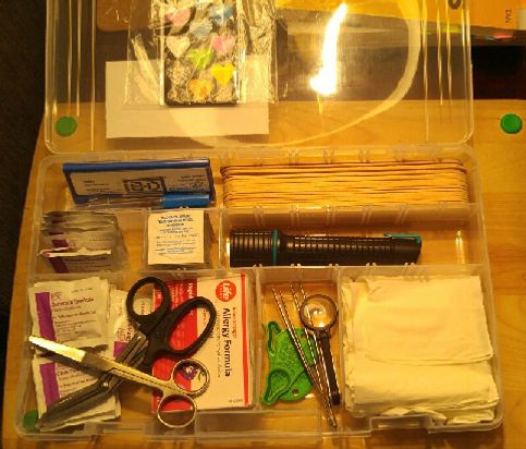 This is stored in a fishing tackle box sold at Cabelas Outfitters, 4 boxes are sold as one package.  The larger compartment in the front (as wide as the box itself) is ideal for larger first aid items.  These boxes each come with extra dividers.