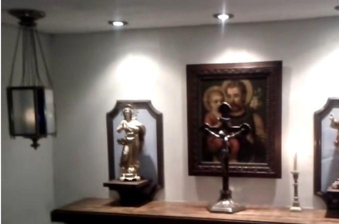 This home oratory is simplicity itself. Notice the details of what could be mirror frames simply hanging over the stucco wall to focus the mind on Our Blessed Mother and the Sacred Heart of Jesus. Also, the beautiful print of Saint Joseph and the Christ Child becomes a warm background to the altar crucifix. The hanging light reminds us of the Presence of Christ our Lord in the Blessed Sacrament, and the hanging censor (which can be used for incense) is a beautiful reminder of the beautiful Roman Catholic Mass and the Priest's and our prayers going up to Heaven. This room can be hidden from sight with a simple shelving unit attached to the solid-wood door, if necessary. 
See this inspiring oratory on youtube: https://youtu.be/lysB7txwLTI  
As the background instrumental piece is quite unpleasant, you may want to mute this.
